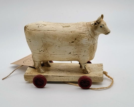 Kuh aus Holz auf Wagen